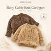 A close-up of a brown cable knit baby cardigan sweater displayed on a light background.