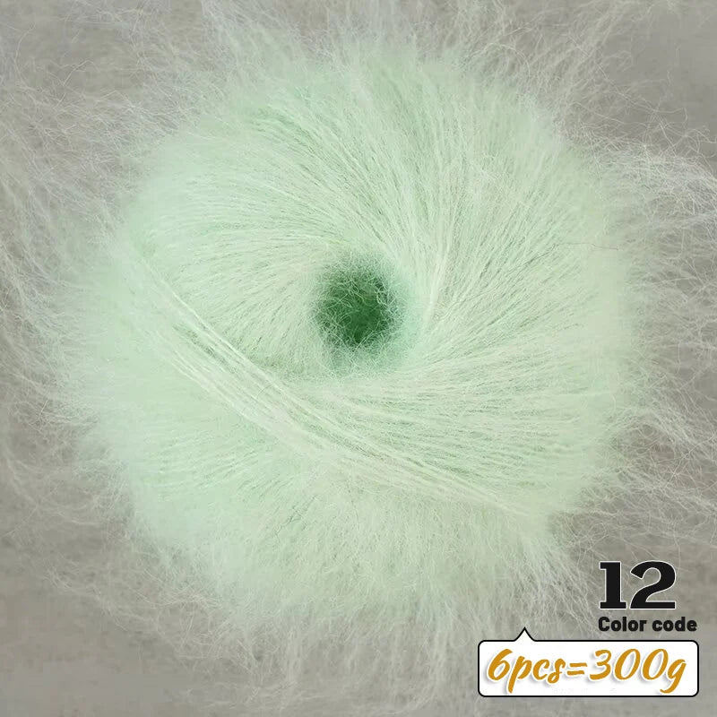 A close-up of light green long-haired alpaca blend yarn showing a central core and surrounding fibers.
