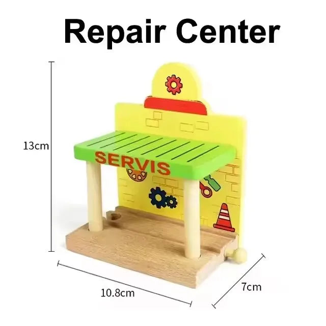 A yellow wooden train track accessory set featuring a service building and green track pieces.