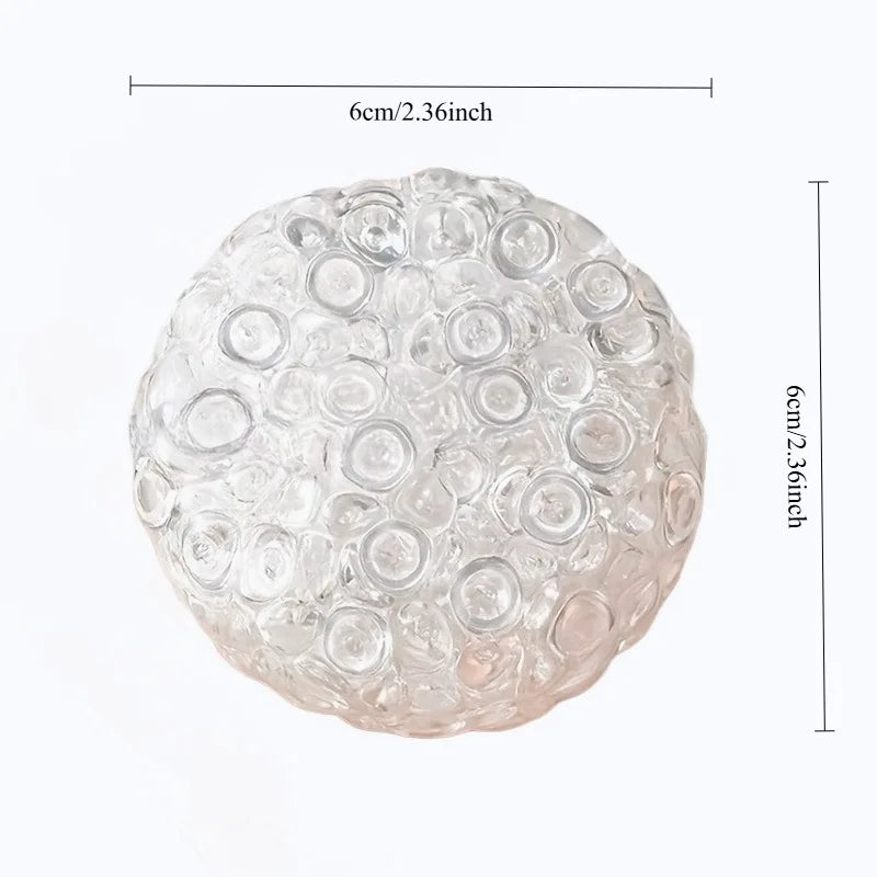 A clear, spherical fidget ball made of soft silicone, used for stress relief.