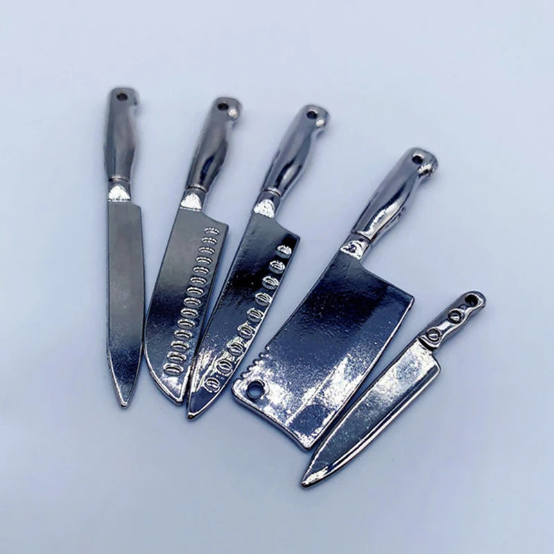 A set of five miniature metal kitchen knives with handles displayed on a light gray background.