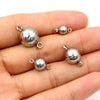 Several silver stainless steel magnetic clasps are shown resting on a person's hand.