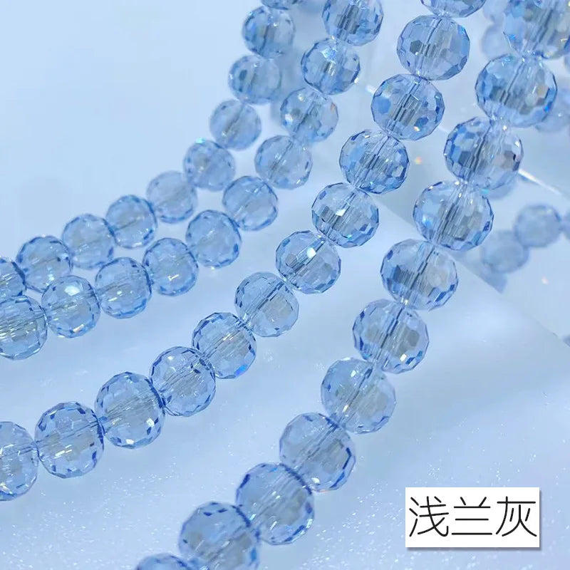 A close-up of a strand of light blue Austrian crystal beads with an AB coating