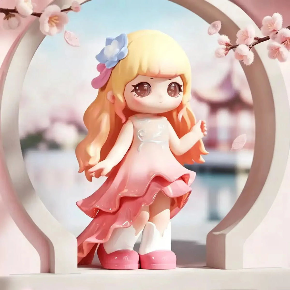 A collectible figurine of a blonde girl with pink hair and a light pink dress is displayed in an oval frame surrounded by che
