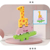 A set of wooden animal stacking blocks featuring a yellow giraffe, a pink dinosaur, and a green crocodile, displayed with mat