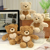 A collection of soft brown and beige plush teddy bears displayed on a wooden surface.