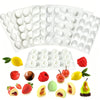 A set of white silicone molds for making various 3D fruit shapes for baking and desserts.