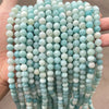 A close-up of strands of light blue and white natural amazonite beads for jewelry making
