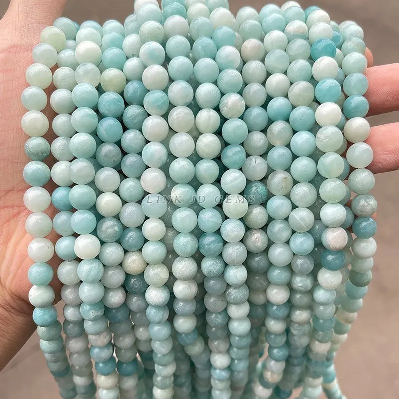 A close-up of strands of light blue and white natural amazonite beads for jewelry making
