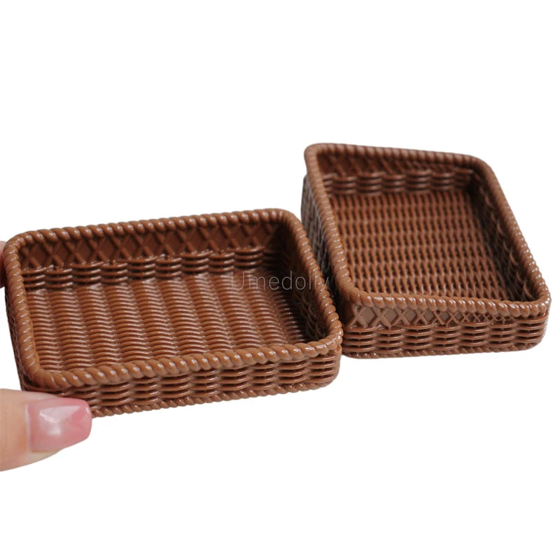 A set of two brown woven baguette-shaped miniature dollhouse baskets.