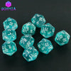 A collection of ten glittery teal polyhedral dice scattered on a dark surface.