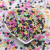 A bowl filled with colorful cartoon polymer clay slices in various pastel colors for slime and craft projects