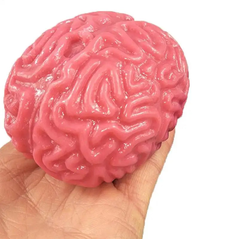 A pink, brain-shaped stress relief ball is held in a person's hand.
