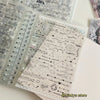 A clear plastic sheet of decorative stickers and doodles for journaling and scrapbooking inside a spiral-bound book.