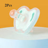 Two soft silicone baby pacifiers in pink and mint green resting on a white surface.