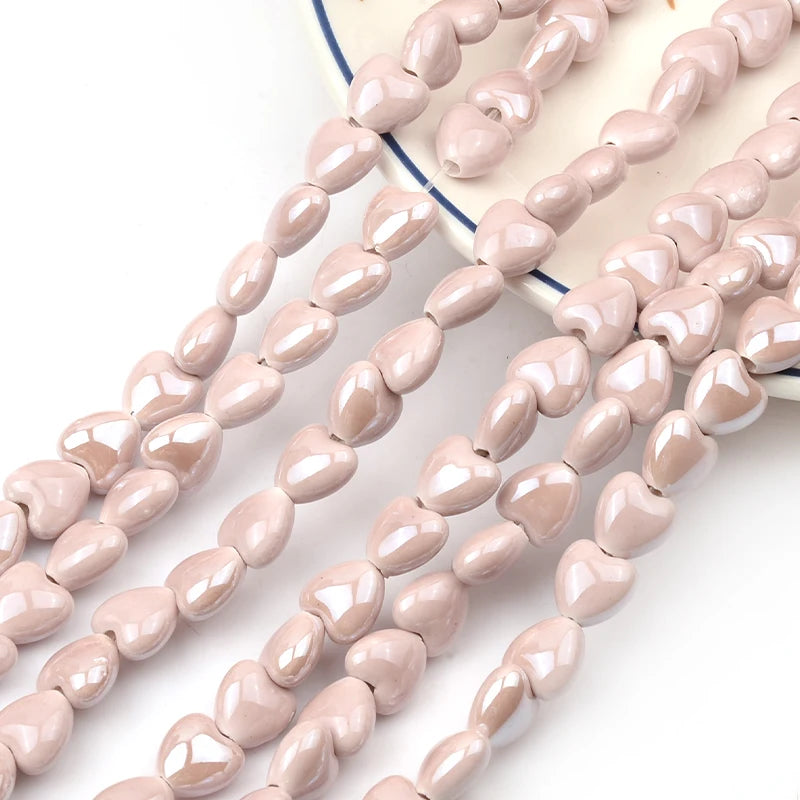 A string of light pink heart-shaped acrylic beads is displayed on a white background.