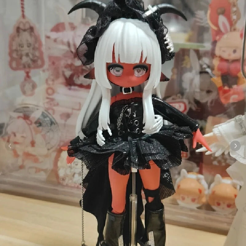 An articulated vinyl art figure of a character with white hair and red eyes wearing a black outfit.