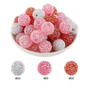 A bowl filled with various shades of pink and red rhinestone resin bayberry beads for jewelry making