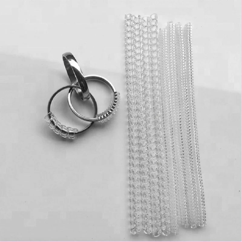 A set of transparent ring size adjusters, consisting of a ring and multiple clear plastic rings.