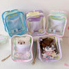 A set of five pastel colored storage pouches with clear windows and attached keychains for dolls.