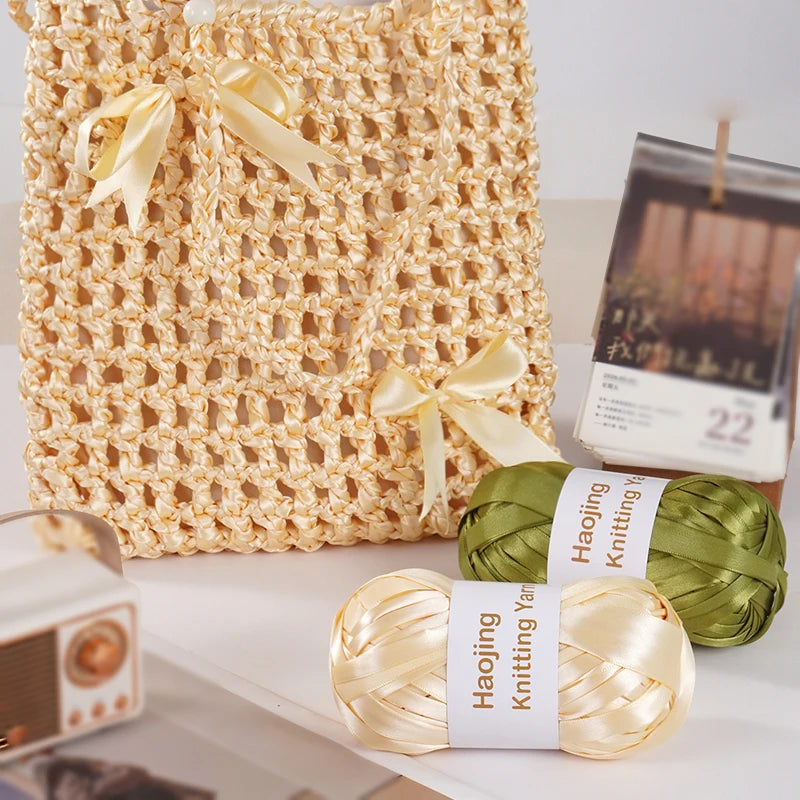 A set of nine-color satin ribbon yarn for hand weaving and bag making displayed next to a woven bag.