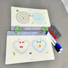 A set of reusable magic drawing workbook pages featuring swirling designs and pens on a gray surface.