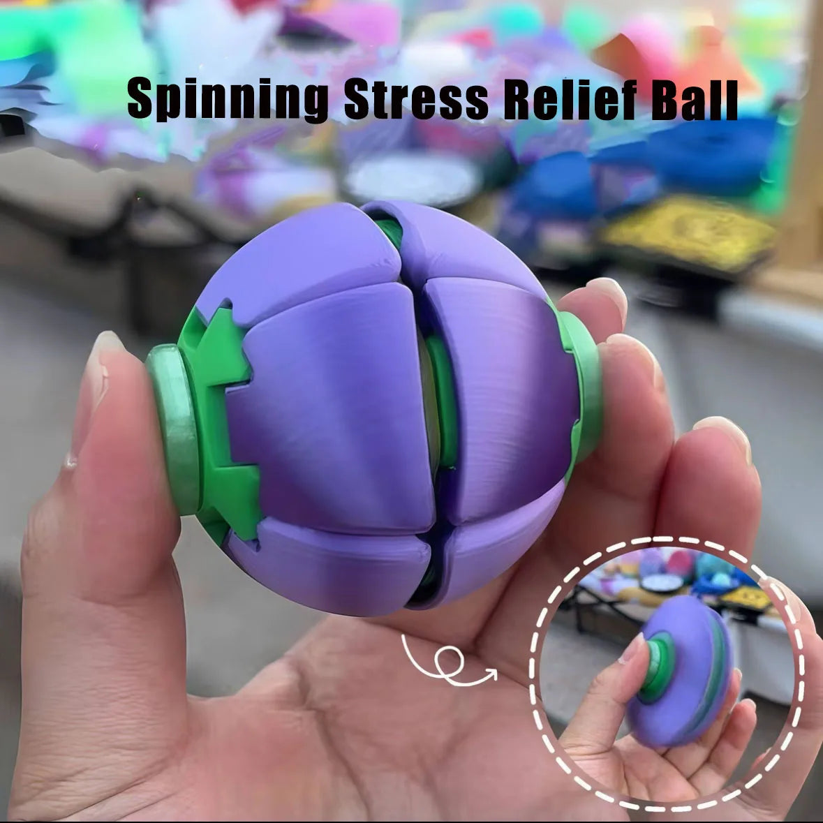 A hand holds a purple spinning stress relief ball with green accents against a blurred background.