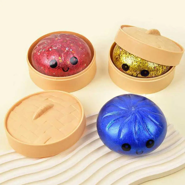Glittering sensory compress toys in cardboard containers, including a red and a blue one.