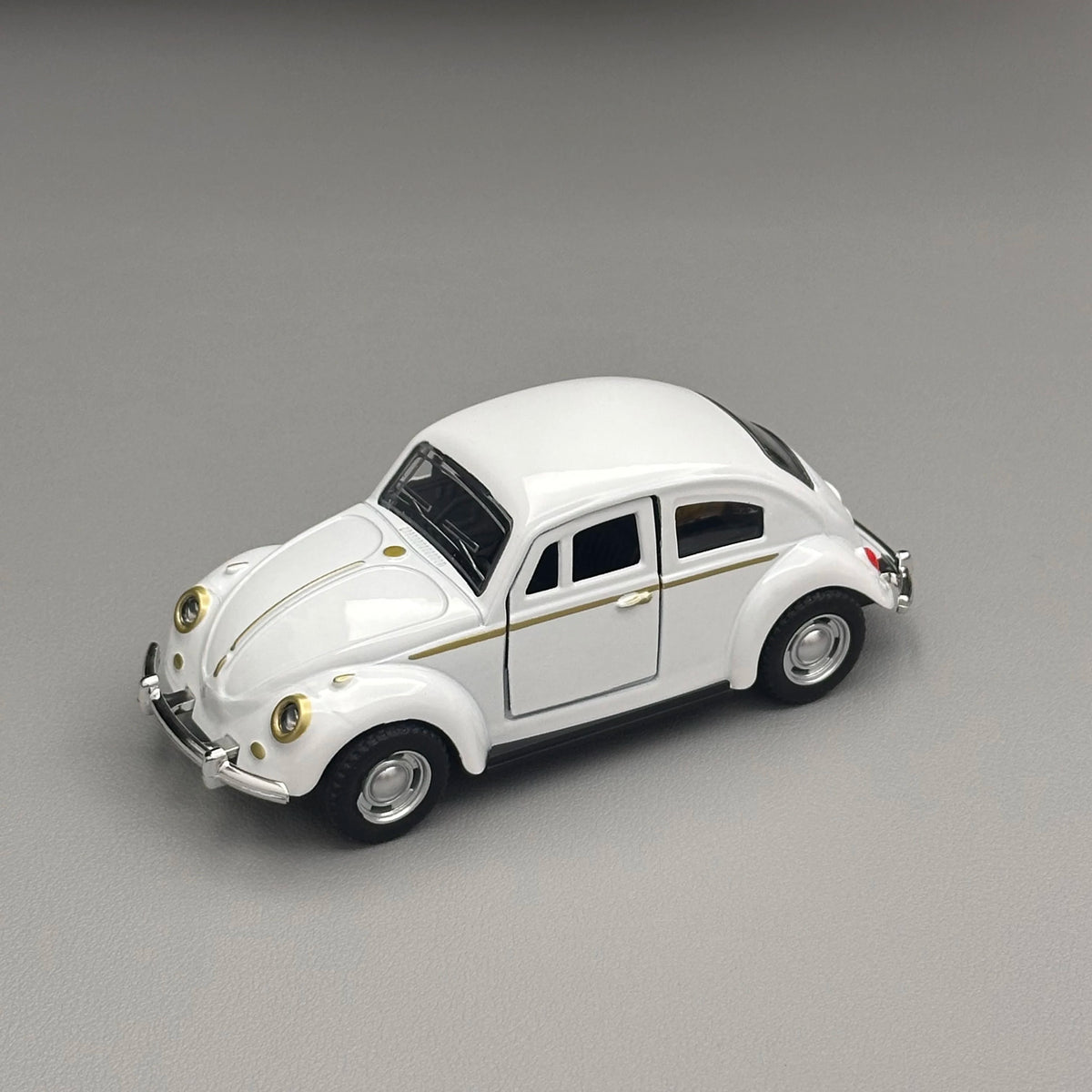 A white classic retro Beetle diecast model car with black roof and gold trim, shown from the side.