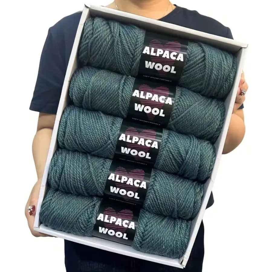 A box displaying a 5-pack of teal alpaca wool yarn skeins for knitting and crochet.