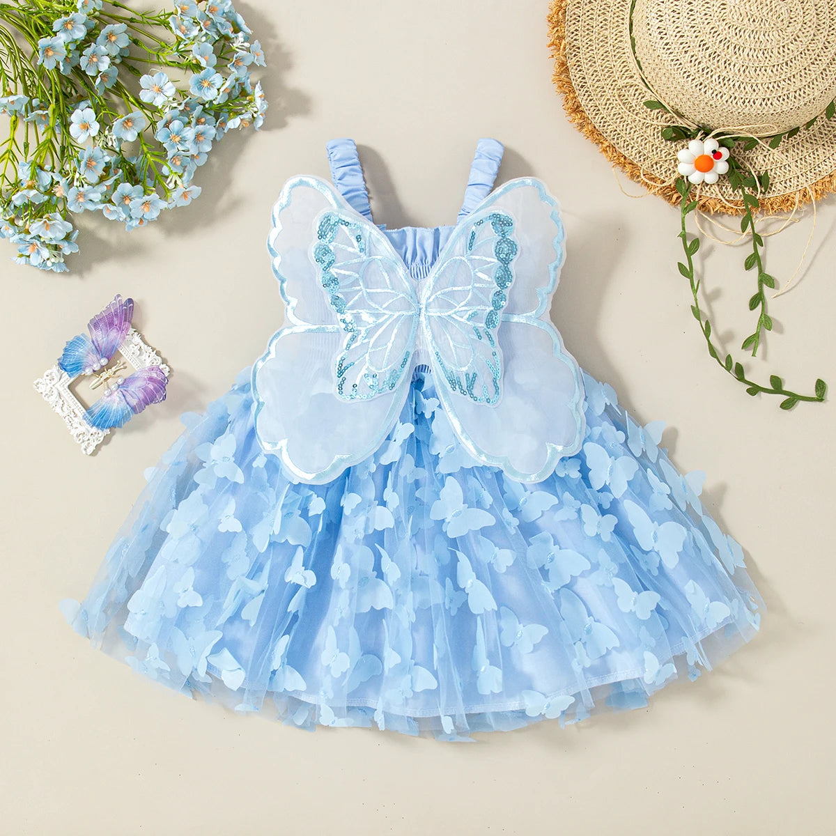 A light blue tulle butterfly dress for a baby girl with sheer butterfly wings and floral accents.