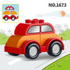 A red and orange construction vehicle building block set with large wheels is shown on a green landscape.