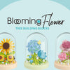 Three glass-encased flower building blocks in yellow, blue, and pink colors.