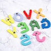 A collection of wooden magnetic alphabet letters in various colors including red, yellow, blue, and green scattered on a whit