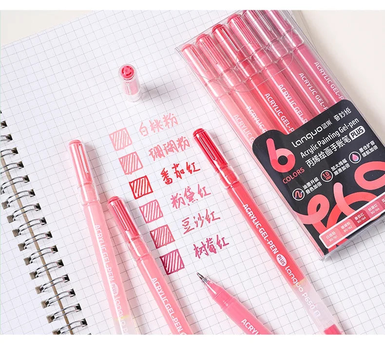 A set of six vibrant acrylic gel pens in various shades of pink and red laid out on a white grid paper.