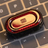 A close-up of a metallic fidget slider with a gem design resting on a keyboard.