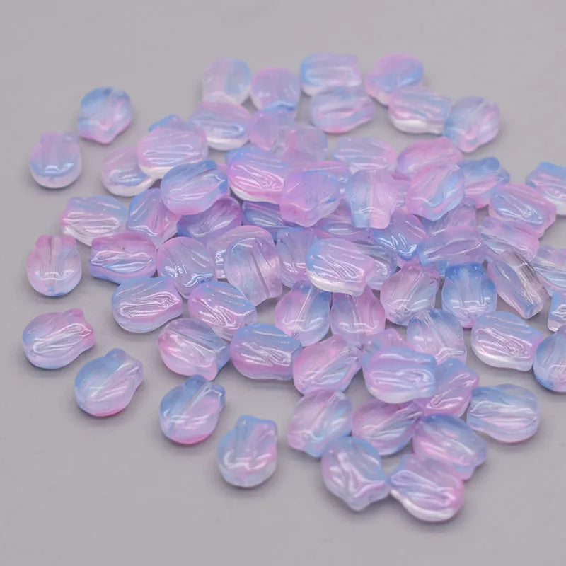A pile of iridescent pink and blue tulip flower glass beads.