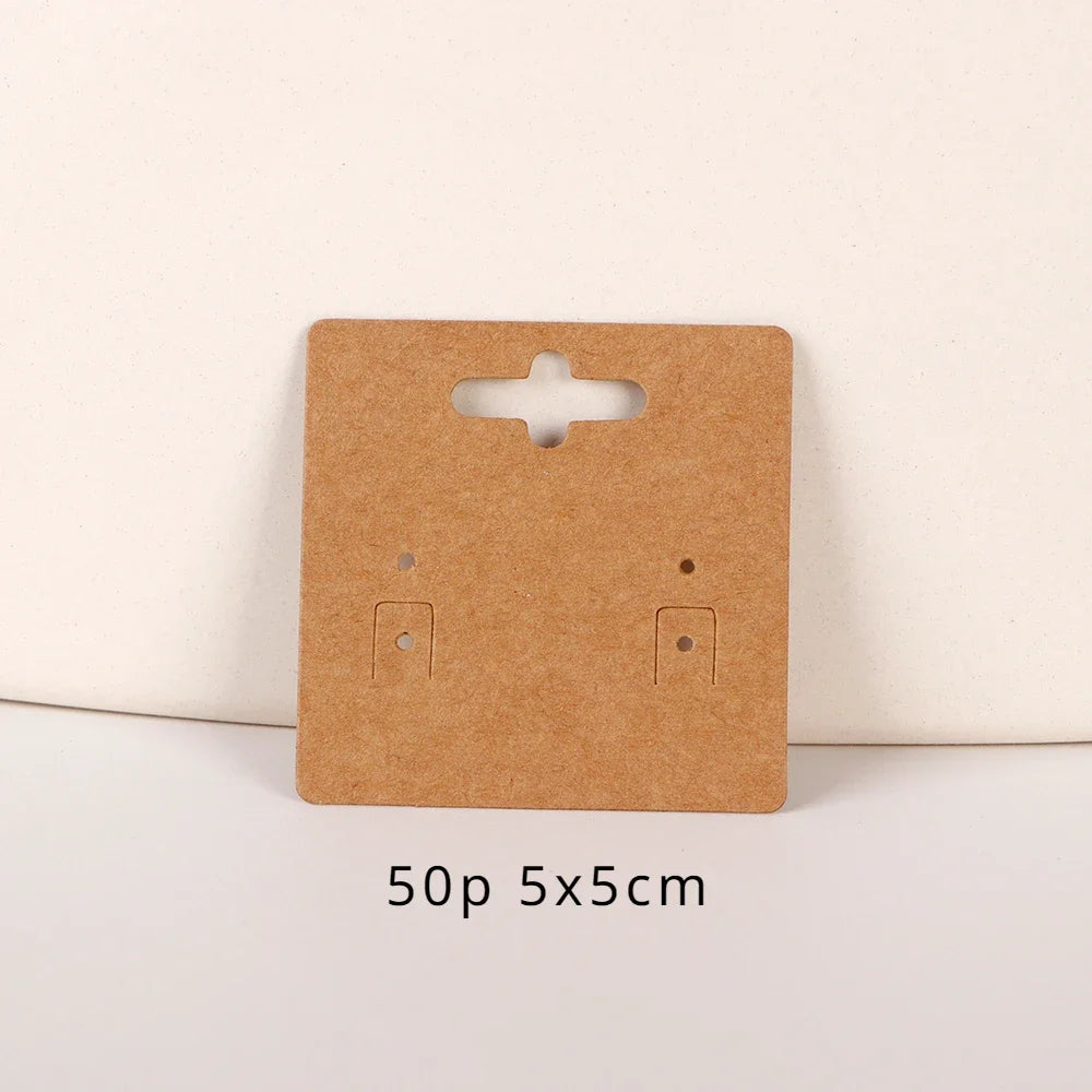 A rectangular brown kraft card with a die-cut slot and two small openings for jewelry display.