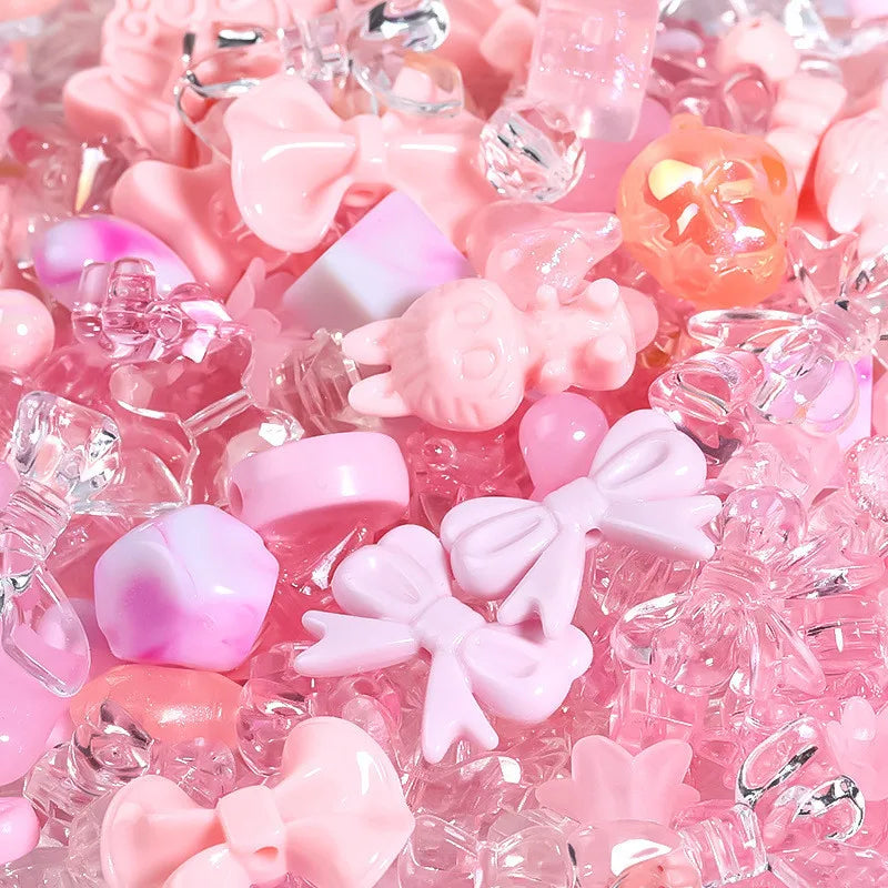 A close-up of mixed pink and clear acrylic loose beads for jewelry making.