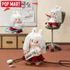 A white vinyl plush of a monster character with large ears and glasses is shown in various poses.