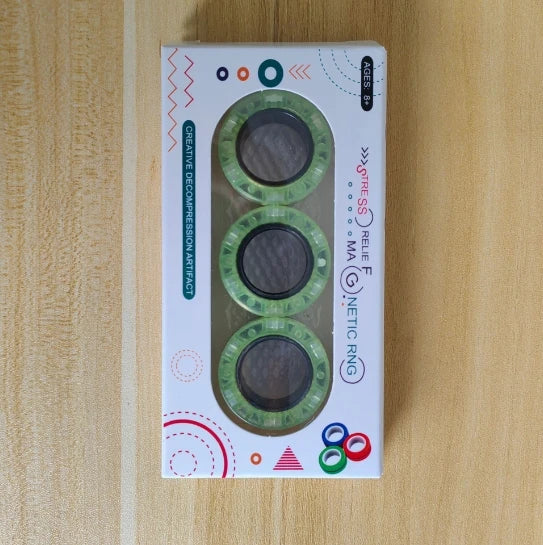 A box containing three green magnetic fidget spinning rings for stress relief.