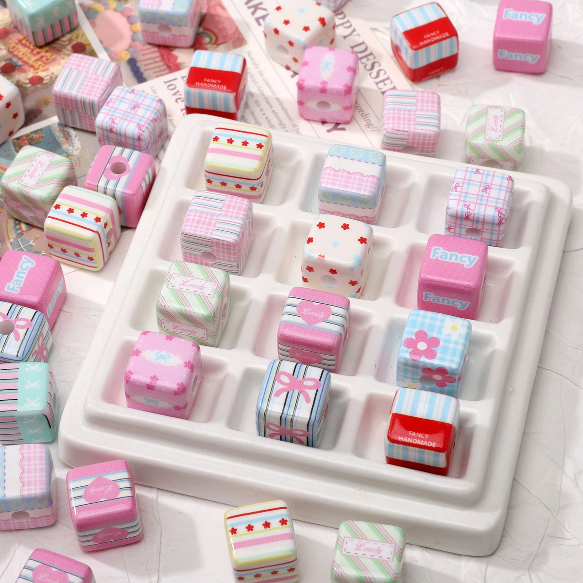 Pink acrylic flower print beads with bow charms for DIY phone and bag accessories displayed in a white tray