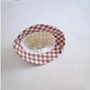 A round bucket hat with a checkered pattern in purple and cream fabric.
