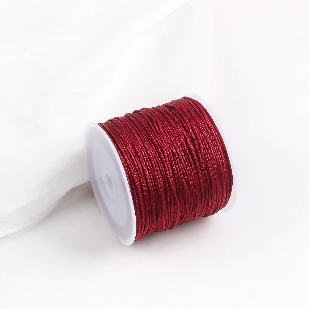A roll of deep red macrame cord for jewelry making and crafts.