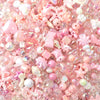 A close-up of pink and iridescent acrylic bow beads for DIY jewelry making