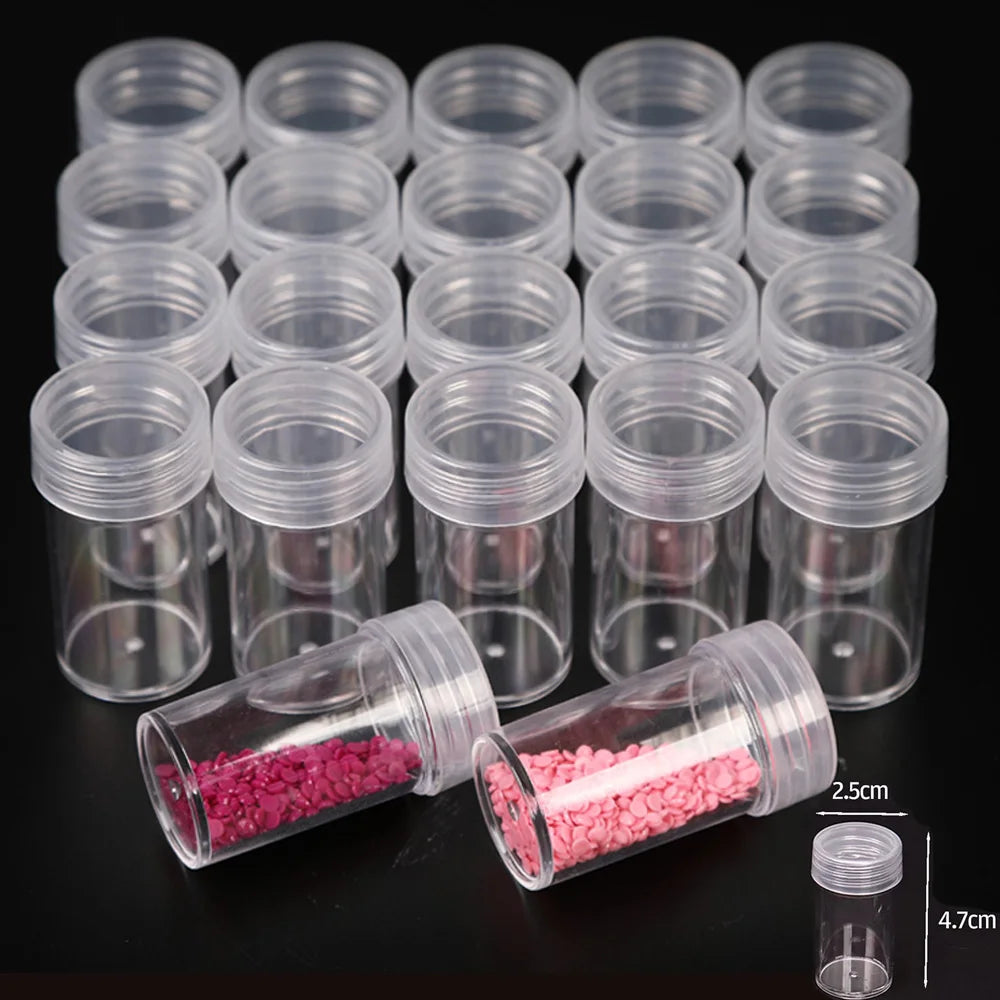 A collection of clear plastic storage bottles for diamond painting beads and crafts, including small vials filled with pink b