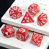 A set of red marble dragon pattern polyhedral dice displayed on a white textured surface.