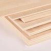 Stacked light wood craft sheets showing various grain patterns and thicknesses.