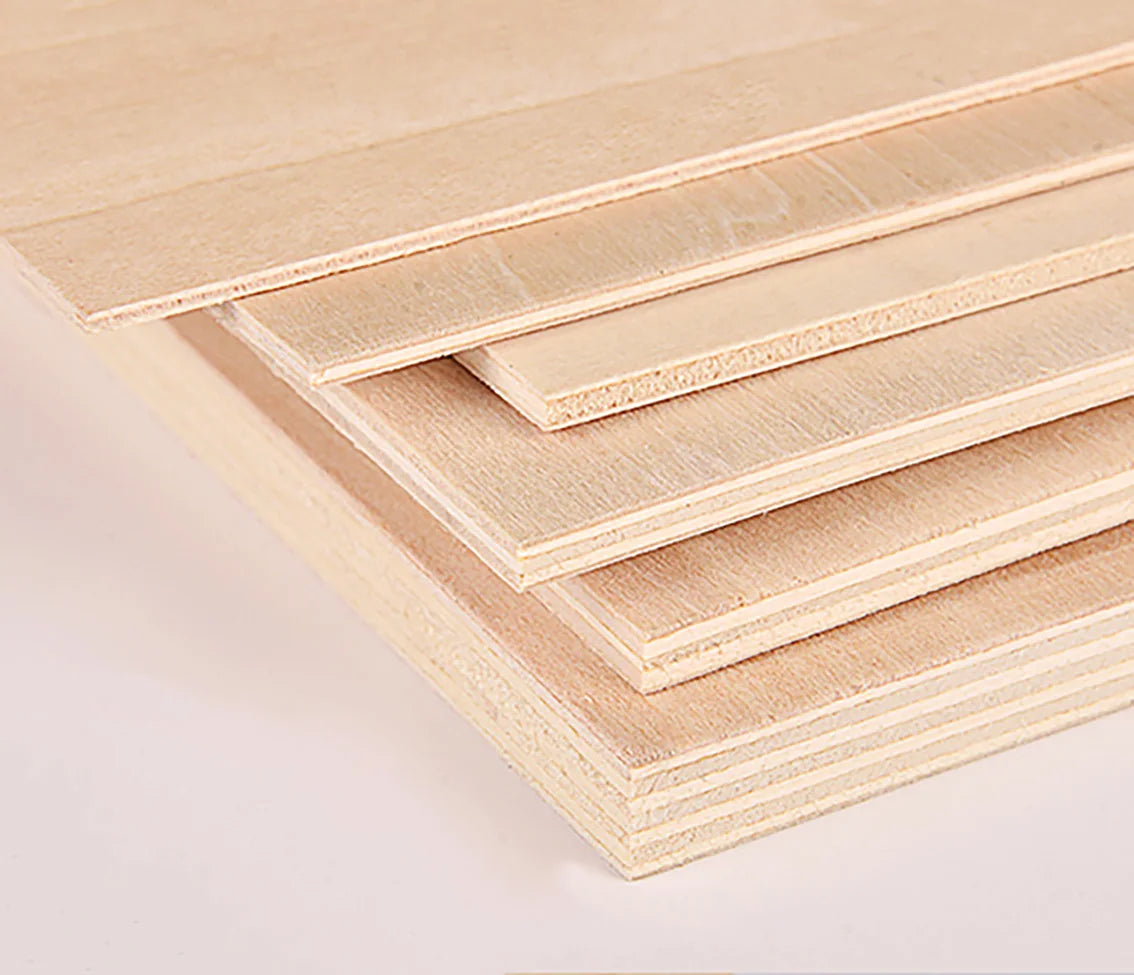 Stacked light wood craft sheets showing various grain patterns and thicknesses.