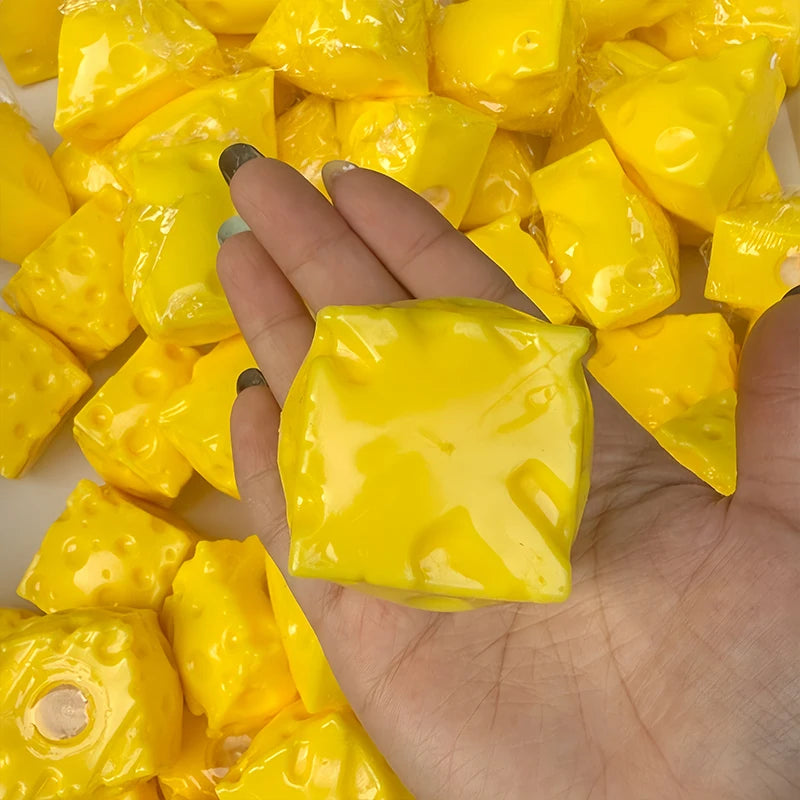 A hand holds a pile of bright yellow, squishy cheese stress balls.